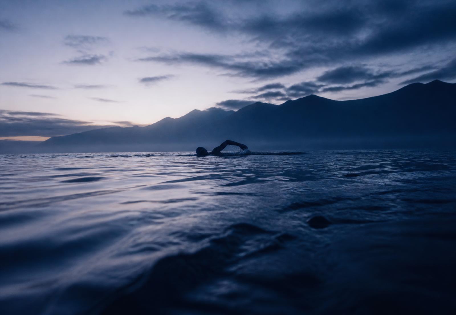 Schwimmer im offenen Wasser bei Morgendämmerung